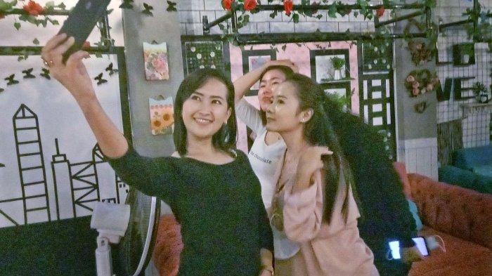 Astri dan kawannya sedang berswafoto di kedai Kopi Kabut Mican, Pasirkareumbi, Kabupaten Subang.