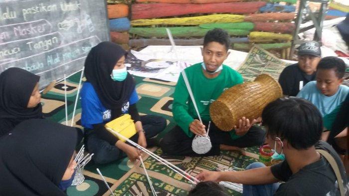 Mujib saat melatih pemuda memanfaatkan koran bekas menjadi anyaman di Sekolah Alam Motekar Kampung Cibunar, Desa Sukajadi, Sadananya, Ciamis, Minggu (18/10)
