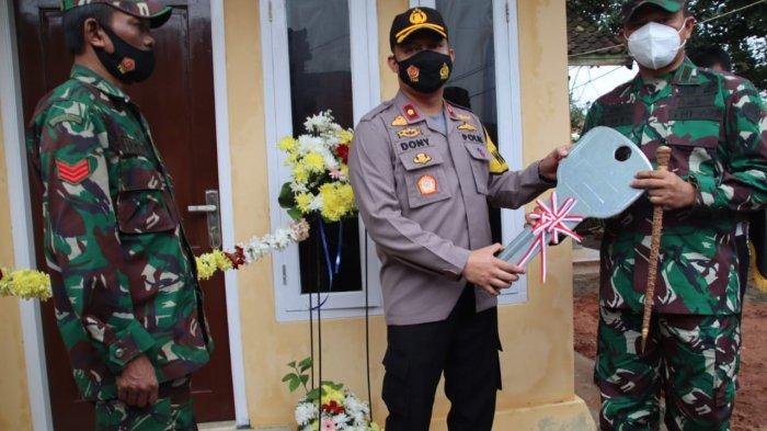 Waka Polres Subang, Kompol Dony Eko Wicaksono (tengah) menyerahkan kunci rumah kepada Danramil Purwadadi, Subang disaksikan Kopka Hamim (kiri) di Dusun Kaliwadas, Desa Pagon, Kecamatan Purwadadi, Subang, Kamis (21/1/2021)