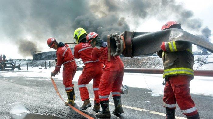 Petugas saat memadamkan api kilang minyak Balongan Indramayu dengan menggunakan alat Terminator Canon Foam atau meriam pelontar busa
