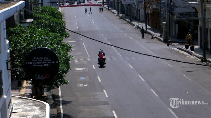 Pengendara sepeda motor melintasi Jalan Oto Iskandar Dinata, Kota Bandung, Jawa Barat, pada saat diberlakukannya Pembatasan Sosial Berskala Besar (PSBB), Kamis (14/5/2020). Kawasan Pasar Baru Kota Bandung ini setiap tahun pada bulan Ramadan menjadi daerah yang selalu dipenuhi pengunjung untuk berbelanja menghadapi Lebaran. Namun, tahun ini dengan adanya pandemi virus corona (Covid-19), kawasan ini diberlakukan sebagai wilayah yang masuk dalam daerah yang tertutup bagi pengunjung sehingga terlihat sepi. Tribun Jabar/Zelphi