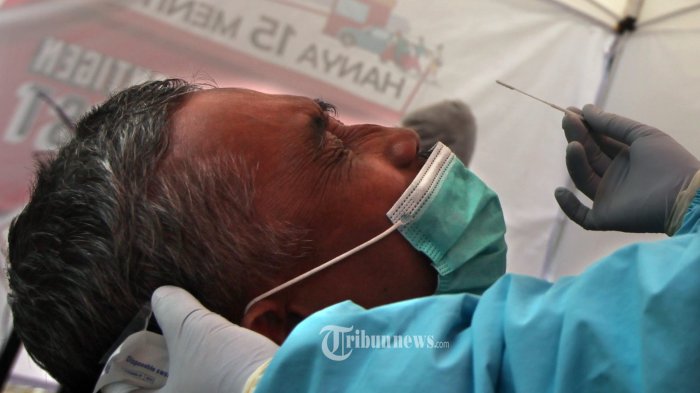 Seorang warga sedang dilakukan pengambilan cairan dari rongga hidung pada kegiatan Swab antigen Test di halaman Gedung The Historich Jalan Gatot Subroto, Kota Cimahi, Jawa Barat, Rabu (27/01/2021). Sudah dua hari kegiatan swab antigen test dilakukan di lokasi ini sebagai langkah mempermudah warga untuk melakukan test tersebut dengan cara cepat dan hanya membayar Rp.235 ribu. Hasil tes akan keluar dalam waktu 15 menit setelah cairan dari rongga hidung diambil. Seperti diutarakan dr. Pontia Aprilia, sebagai penanggung jawab dari Quick swab . Waktu pelaksanaan dilakukan setiap hari dari jam 08.00 pagi hingga jam 17.00. Kegiatan ini berlangsung atas kerjasaama pihak penyelenggara dengan @The Historich, Dinas Kesehatan Kota Cimahi, Ajendam III Siliwangi.