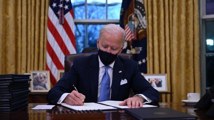 Presiden AS Joe Biden duduk di Oval Office saat dia menandatangani serangkaian perintah di Gedung Putih di Washington, DC, setelah dilantik di US Capitol pada 20 Januari 2021. Presiden AS Joe Biden menandatangani serangkaian perintah eksekutif untuk meluncurkan pemerintahannya, termasuk keputusan untuk bergabung kembali dengan kesepakatan iklim Paris. Perintah tersebut ditujukan untuk membalikkan keputusan pendahulunya, membalik proses keluar dari Organisasi Kesehatan Dunia, mengakhiri larangan masuk dari sebagian besar negara mayoritas Muslim, memperkuat perlindungan lingkungan dan memperkuat perang melawan Covid-19.