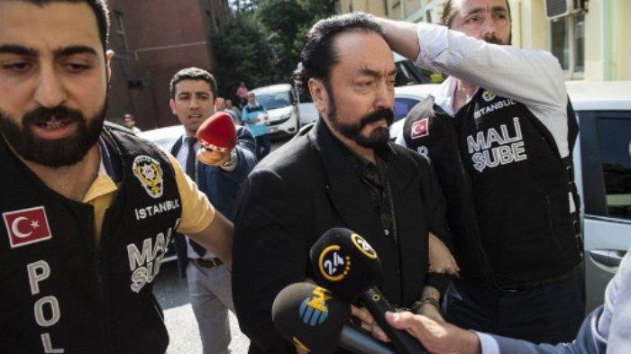 (FILES) Dalam foto file ini diambil pada 11 Juli 2018 petugas polisi Turki mengawal televangelist dan pemimpin sekte, Adnan Oktar (tengah) di Istanbul, saat dia ditangkap atas tuduhan penipuan.
Pengadilan Turki pada 11 Januari 2021 menghukum seorang televangelis Muslim yang mengelilingi dirinya dengan wanita berpakaian minim yang dia sebut