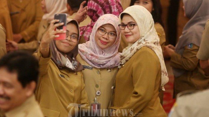 Pegawai Negeri Sipil (PNS) saat berselfie ditengah kerumunan pegawai saat acara halal bihalal dengan sejumlah Pegawai Negeri Sipil (PNS) di Gedung Balaikota, Jakarta Pusat, Senin (10/6/2019). Acara tersebut diikuti oleh ratusan pegaiwai balaikota Jakarta.