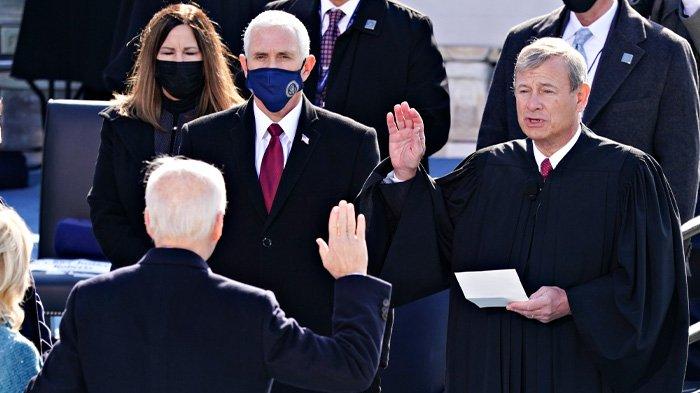 John Roberts, ketua Mahkamah Agung AS (kanan) mengambil sumpah jabatan kepada Presiden Amerika Serikat Joe Biden (membelakangi lensa)saat upacara pelantikan di Front Barat Capitol AS pada 20 Januari 2021 di Washington, DC. Joe Biden menjadi presiden Amerika Serikat ke-46.