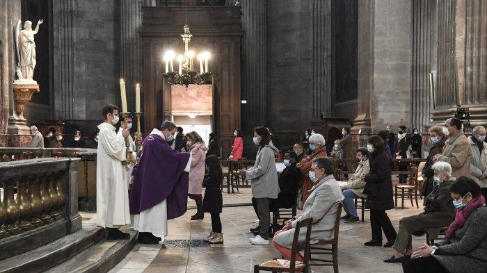 FOTO: Orang-orang menghadiri kebaktian di gereja Saint-Sulpice di Paris pada 29 November 2020 saat misa dilanjutkan di Prancis menyusul pemerintah melonggarkan pembatasan penguncian Covid-19 dengan hanya 30 orang yang diizinkan per gereja.