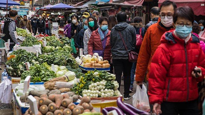 Orang-orang yang memakai topeng mengunjungi pasar makanan segar di Hong Kong pada 29 Januari 2020, sebagai langkah pencegahan setelah wabah virus yang dimulai di kota Wuhan di Cina. Virus yang sebelumnya tidak dikenal telah menyebabkan alarm karena kemiripannya dengan SARS (Severe Acute Respiratory Syndrome), yang menewaskan ratusan di seluruh daratan Cina dan Hong Kong pada 2002-2003.