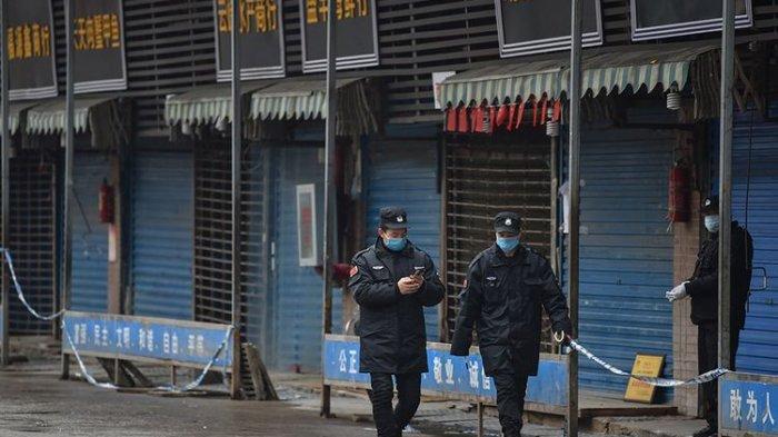 Petugas keamanan berpatroli di pasar ikan tradisional Huanan di kota Wuhan, China, Jumat (24/1/2020). Pasar ikan itu ditutup setelah virus corona yang mematikan dideteksi berasal dari pasar itu.(AFP/HECTOR RETAMAL)