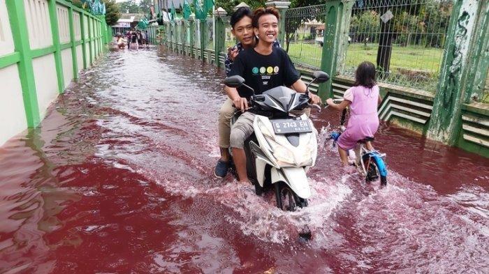 pengendara-melintasi-genangan-air-banjir-berwarna-merah-di-kelurahan-jenggot.jpg