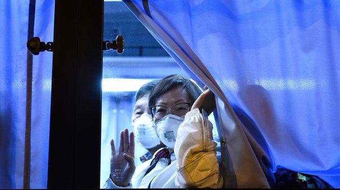 Seorang penumpang AS melambai kepada para wartawan ketika tiba di Bandara Haneda, di Tokyo pada 17 Februari 2020 setelah turun di Yokohama dari kapal pesiar Diamond Princess, tempat orang-orang dikarantina di dalam pesawat karena kekhawatiran akan virus corona COVID-19 yang baru. Orang Amerika mulai meninggalkan kapal pesiar yang dikarantina di Jepang pada 17 Februari 2020, untuk naik ke pesawat sewaan ketika jumlah kasus virus corona baru yang didiagnosis di kapal itu melonjak menjadi 355. Kazuhiro NOGI / AFP
