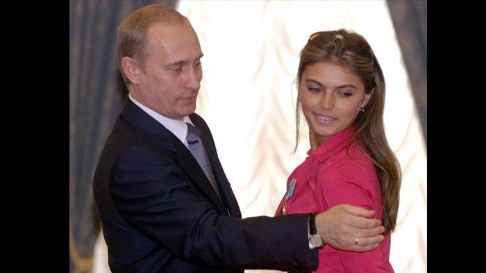 Vladimir Putin bersama Alina Kabaeva tahun 2004 saat Alina menerima penghargaan sebagai atlet senam Rusia. (AFP/GETTY IMAGES VIA THE SUN)