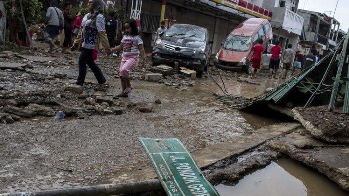 Sejumlah warga melintas di area pemukiman yang sempat terendam banjir di kawasan Pondok Gede Permai, Jati Asih, Bekasi, Jawa Barat, Kamis(2/1/2020).