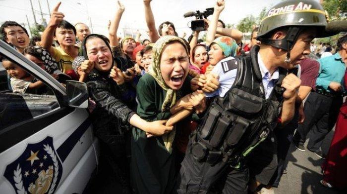 Sekelompok orang Uighur menghalau polisi dalam aksi protes di Provinsi Xinjiang, China.