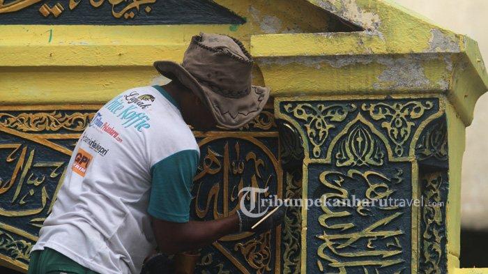 Pekerja tengah mengecat tulisan kaligrafi pada pintu gerbang Masjid Raya di Senapelan Pekanbaru, Minggu (13/9/2020).