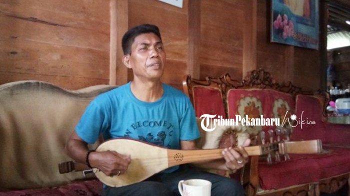 Zainudin, warga Kampung Zapin Desa Meskom tengah asyik memainkan alat musik gambus kala tribunpekanbaruwiki.com berkunjung