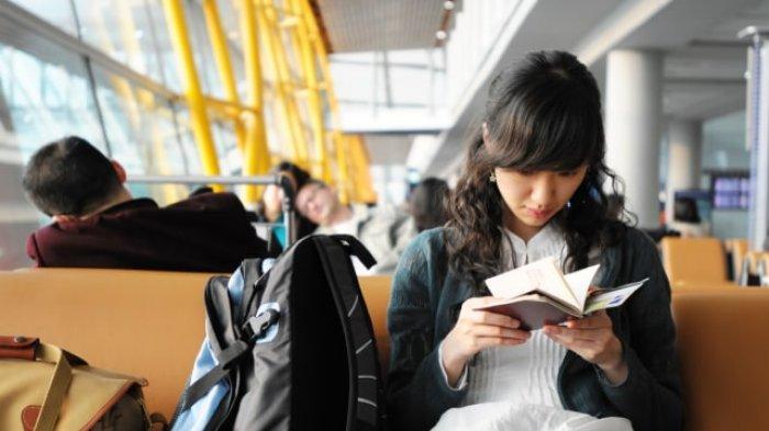 Mengecek boarding pass di bandara