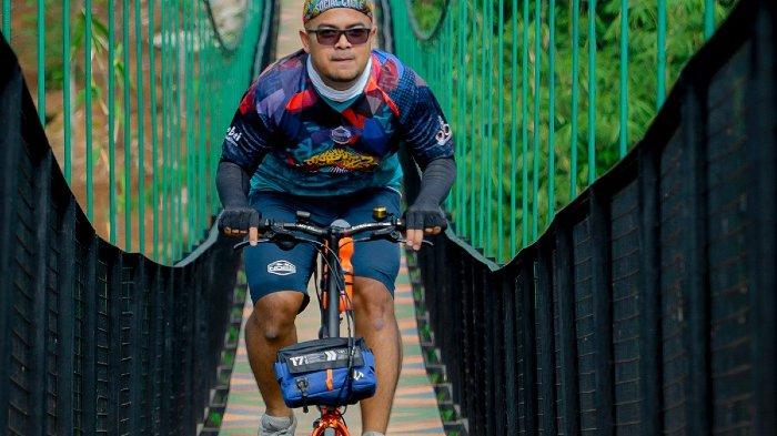 Pesepeda dari Komunitas Troy Bogor (Trobos) saat melintasi Jembatan Rawayan Taruma Nagara yang memiliki panjang 125 meter dan melintang tinggi diatas Kali Cisadane, Rancabungur, Kabupaten Bogor, Jawa Barat, Kamis (3/3/2022). Jembatan gantung itu tidak jauh dari TPU Rancabungur.