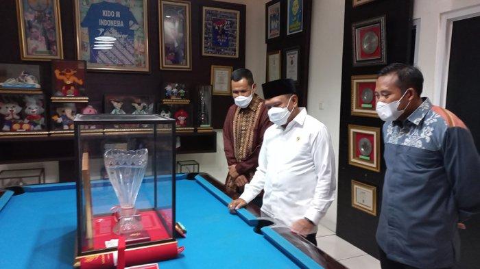 Menpora Zainudin Amali sedang melihat medali, trophy dan piagam penghargaan yang diraih oleh Markis Kido selama menjadi pebulutangkis nasional dan mengharumkan nama Indonesia di dunia internasional