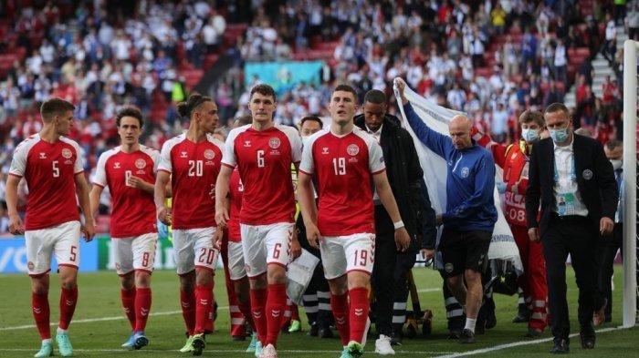 Pemain Denmark mengawal paramedis saat mereka mengevakuasi gelandang Christian Eriksen (tidak terlihat). Pertandingan sepak bola Grup B UEFA EURO 2020 antara Denmark dan Finlandia di Stadion Parken di Kopenhagen pada 12 Juni 2021 ditangguhkan oleh pihak UEFA. Friedemann Vogel / AFP / POOL