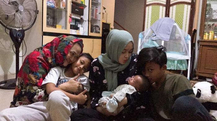 Putri Delina saat menggendong adik perempuannya ditemani almarhumam Lina Juabedah