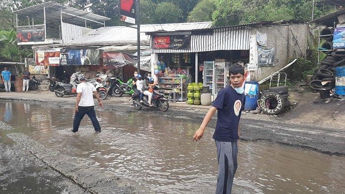 Warga Jalan Curug Nangka memprotes jalan rusak dengan menebar 25kg ikan lele di kubangan jalan di Jalan Curug Nangka, Tamansari, Bogor.