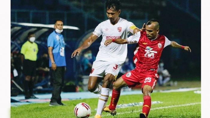 Kapten tim PSM Makasssar, Zulkifli Syukur (kiri) sukses menjaga pergerakan sayap Persija Jakarta Riko Simanjuntak pada laga babak penyisihan grup B