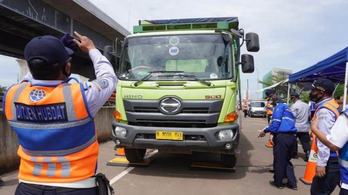 Petugas Dinas Perhubungan sedang mengarahkan truk naik ke timbangan, dalam Operasi ODOL pada Selasa (15/12/2020).