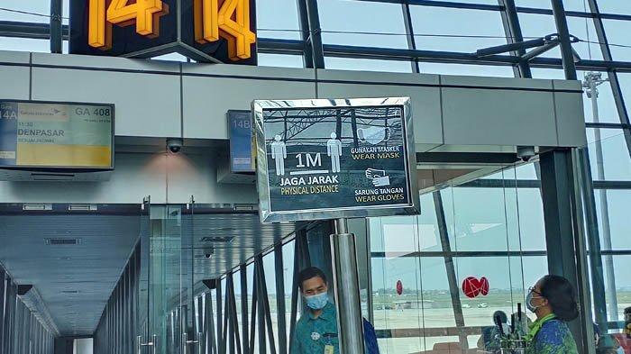 Pengumuman imbauan menjaga jarak saat naik ke pesawat.