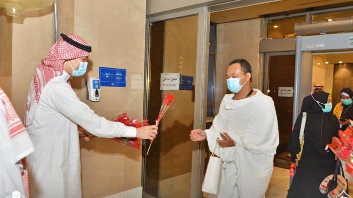Jemaah umrah Indonesia mendapat setangkai bunga mawar dari petugas hotel tempat mereka dikarantina, Minggu (1/11/2020).