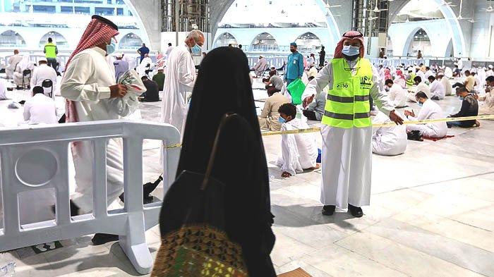 Petugas voluntir (rompi hijau) di Masjidil Haram mengarahkan jemaah. Jawatan Tinggi Pemelihara Dua Masjid Suci merekrut banyak tenaga voluntir menjelang pembukaan kembali ibadah umrah bagi jemaah internasional.