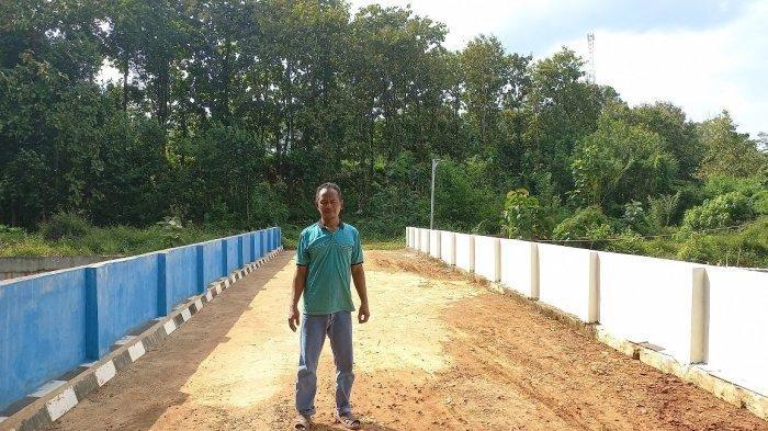 Kholil (58), berpose berdiri di atas jembatan yang dibangun dari kantong pribadinya.Warga Dukug Kedungjogo, Desa Kecapi, Kecamatan Tahunan, Kabupaten Jepara itu mengaku menghabiskan dana pribadi Rp3,7 Miliar untuk merampungkan jembatan berukuran lebar 6 meter dan panjang 22 meter.
