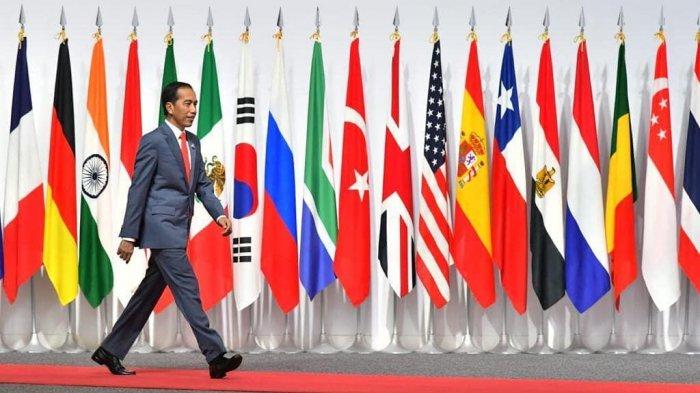 Presiden Joko Widodo (Jokowi) berjalan di atas karpet merah di panggung dan melewati deretan bendera negara G20 di INTEX Osaka.