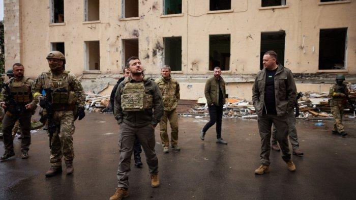 Mengenakan rompi antipeluru, Presiden Ukraina Volodymyr Zelensky menilik bangunan yang hancur di Kharkiv dan sekitarnya, tempat pasukan Rusia mundur dalam beberapa pekan terakhir, Minggu (29/5/2022).