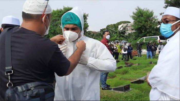 Teddy Syach saat memakai APD untuk ikut memakamkan istrinya, Rina Gunawan di TPU Tanah Kusir Jakarta Selatan, Selasa (3/3/2021).